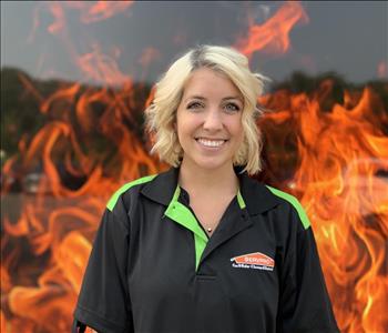 blonde female standing against a fake fire backdrop