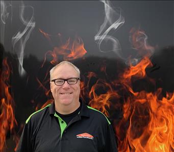 Man with glasses standing against fake fire backdrop
