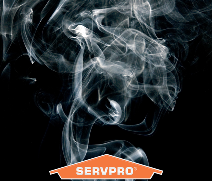 black sky with smoke in the air and the orange servpro logo
